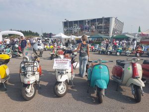 Lambretta parcheggiate all'Eurolambretta 2017 ad Adria, con il cartello del progetto Wild Ride on Lambretta prima della partenza per il giro del mondo.