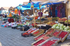 Mercato tradizionale in Azerbaijan con banchi di frutta e verdura fresca.