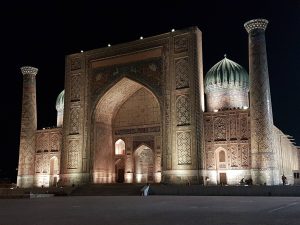 Piazza Registan illuminata di notte a Samarcanda, Uzbekistan, con le storiche madrase ricoperte di mosaici e maioliche, simbolo della Via della Seta.