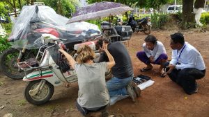 controlla la Lambretta sotto la pioggia prima di entrare a Yangon, in Myanmar