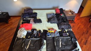 Vestiti tecnici e invernali organizzati sul letto accanto alle borse SHAD per il viaggio verso il Nord Europa.