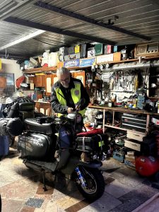 Filippo prepara la Lambretta carica di bagagli nel garage di casa, prima della partenza per il viaggio verso il Nord Europa.