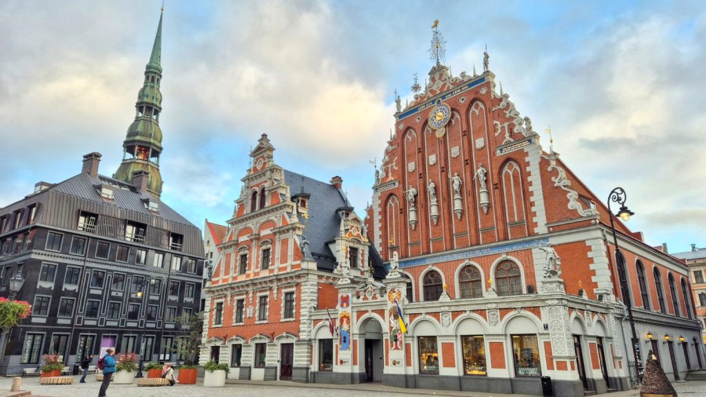 Casa delle Teste Nere nella Piazza del Municipio di Riga, Lettonia, con la facciata in mattoni rossi e l'orologio astronomico.