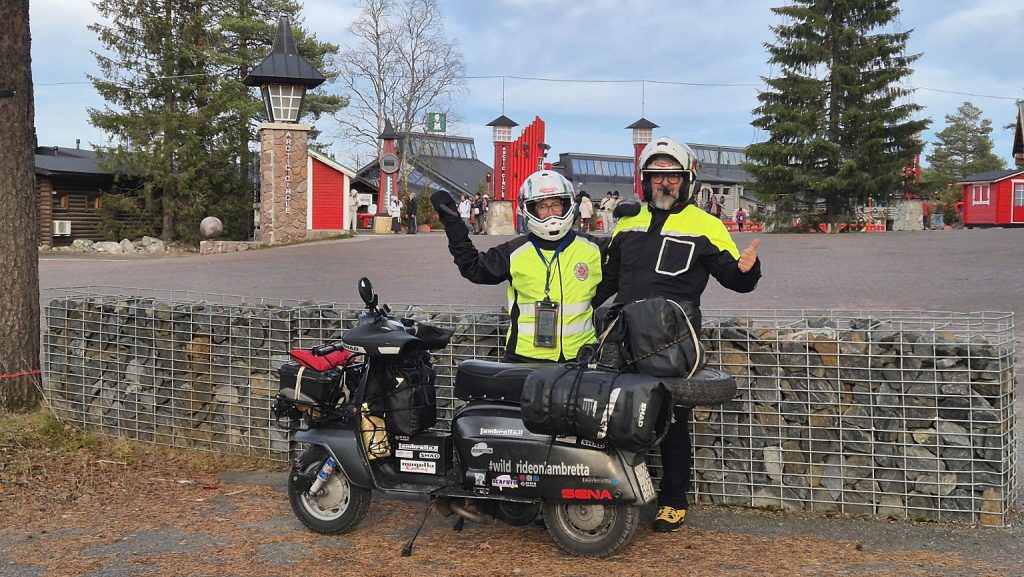 Francesca e Filippo con la Lambretta Xena davanti all'ingresso dell'Arctic Circle a Rovaniemi, in Lapponia finlandese.