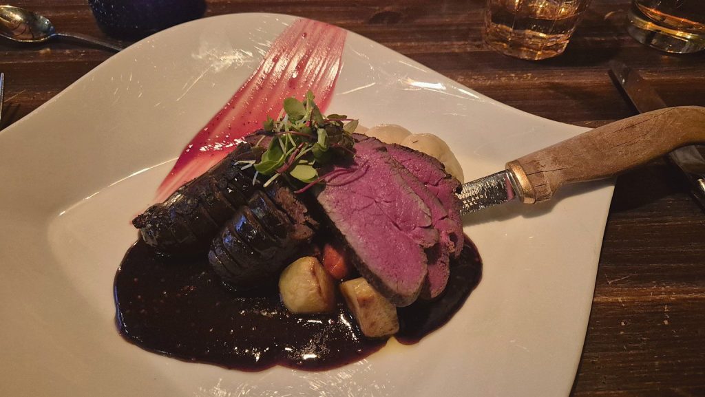 Carne di renna arrosto con salsa scura e contorno, specialità della cucina lappone al ristorante Nili di Rovaniemi.