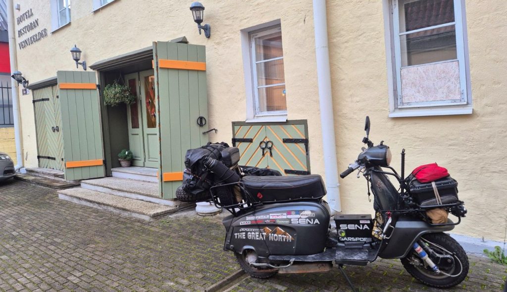 Lambretta Xena carica di bagagli davanti all'Hotel Bern Venn Kelder nel centro storico di Tallinn, Estonia, durante The Great North.