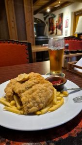 Cotoletta impanata con patatine fritte, limone e birra in un locale austriaco.